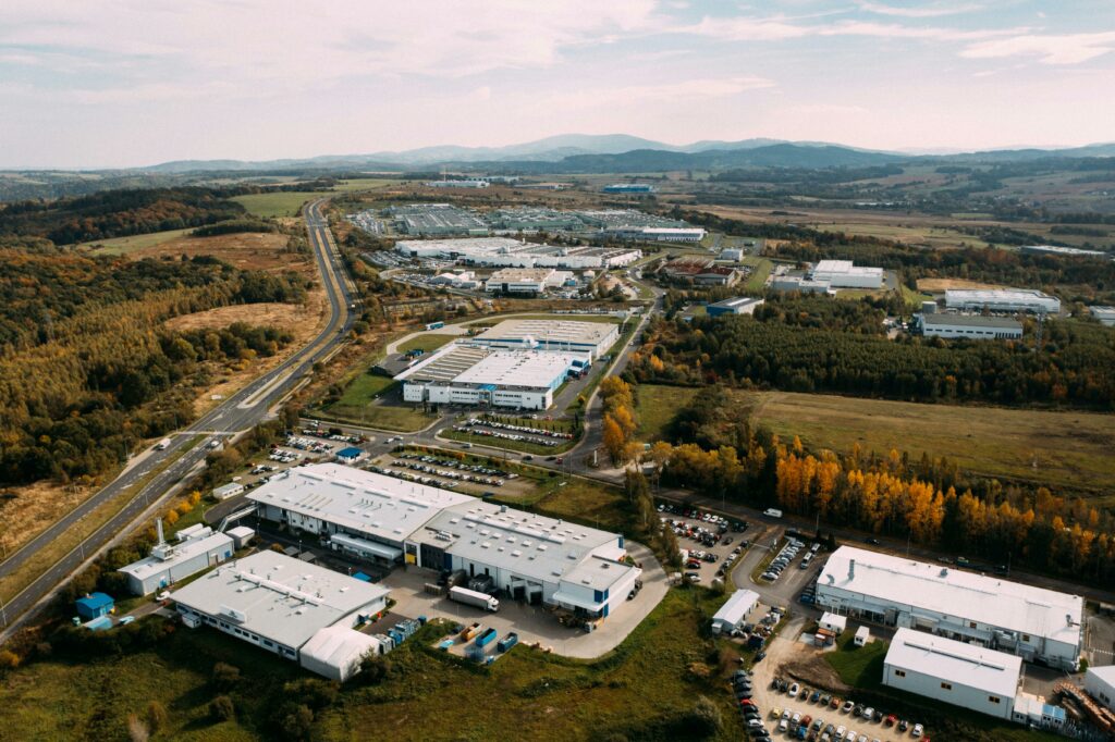 pexels photo 14060483 14060483 Aerial photograph of an expansive industrial complex surrounded by lush countryside and winding roads.